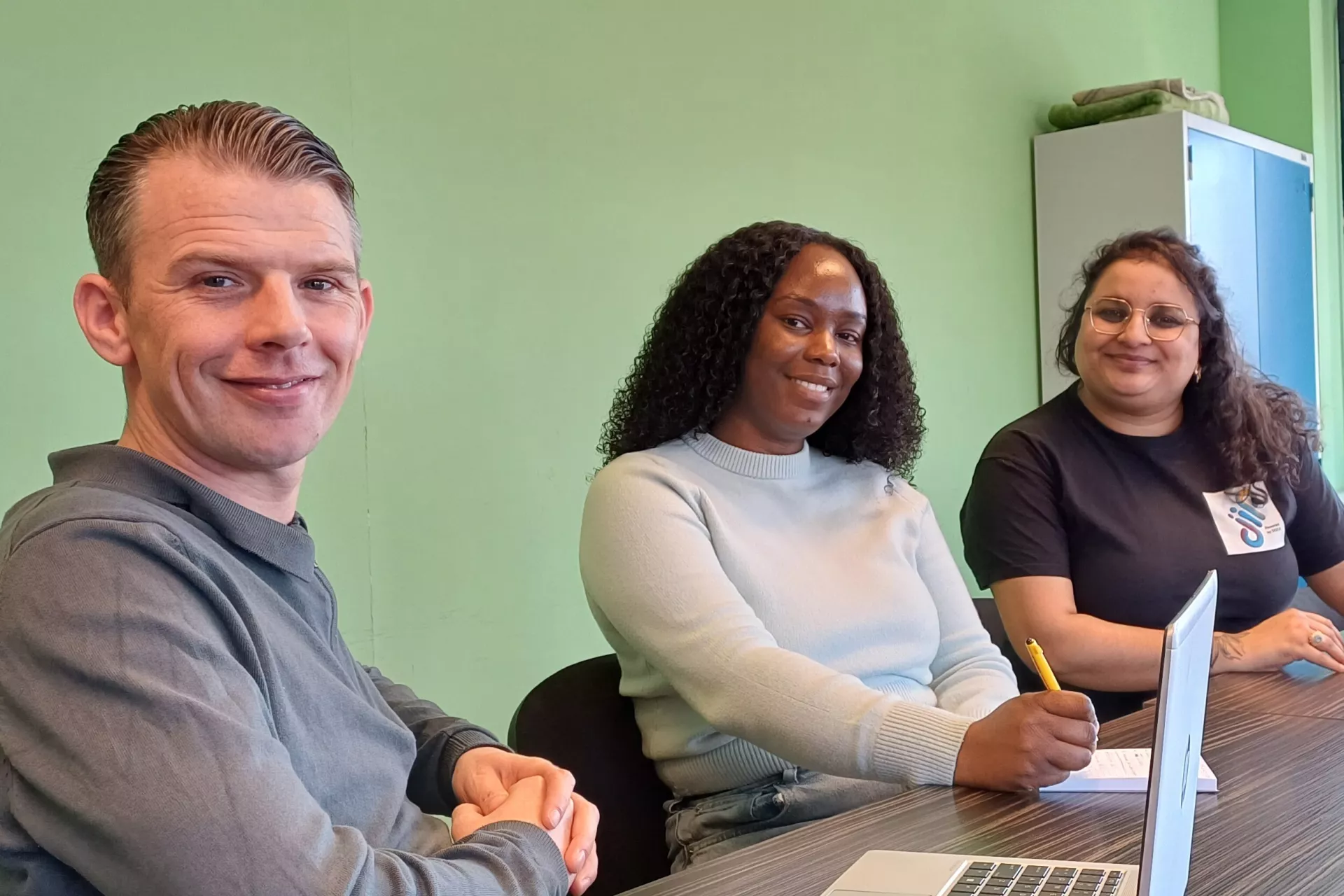 DOCK medewerkers lachend aan een vergadertafel met laptops